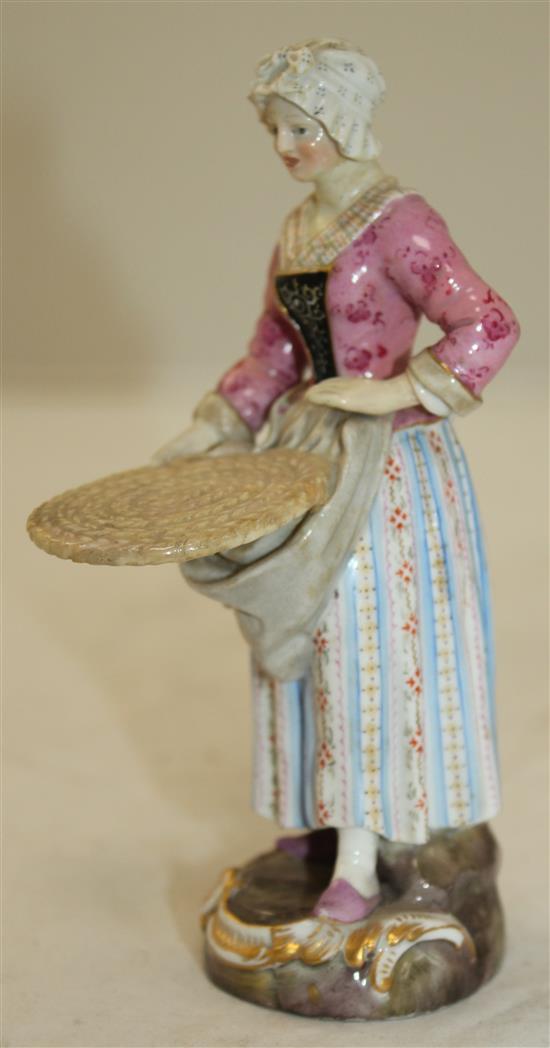 A Meissen figure of a female street vendor, 19th century, 14cm, restored